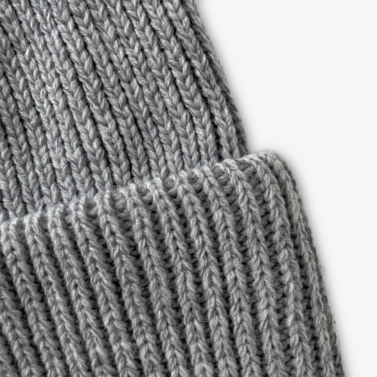 Närbild på garnet på den grå mössan.