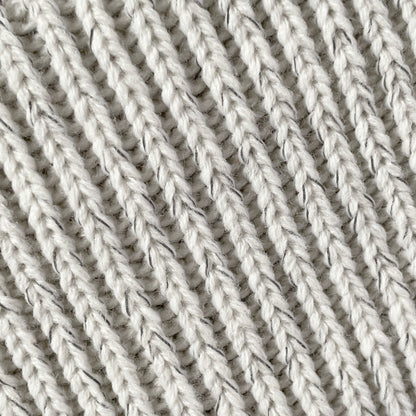 Närbild på reflexgarnet i den beige mössan.